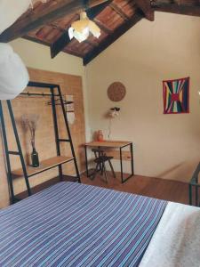 een slaapkamer met een kamer met een bed en een bureau bij Rosa dos Ventos Chalés in Cavalcante