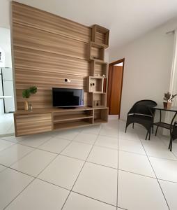 ein Wohnzimmer mit einem TV und einem Tisch in der Unterkunft Ap 2/4 Prox ao shopping in Feira de Santana