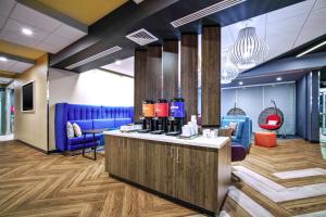 una hall con bar con sedie blu e rosse di Tru By Hilton Goodyear Phoenix West, Az a Goodyear