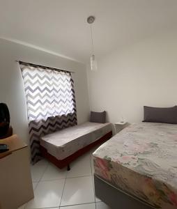 1 dormitorio con 2 camas y ventana. en Ap 2/4 Prox ao shopping, en Feira de Santana