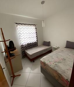 1 dormitorio con 2 camas y ventana en Ap 2/4 Prox ao shopping en Feira de Santana