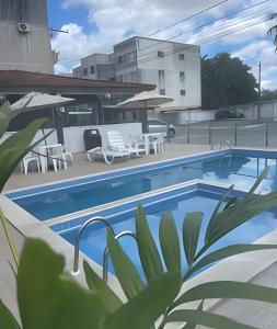 a swimming pool with tables and chairs on a building at Ap 2/4 Prox ao shopping in Feira de Santana