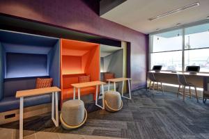 a waiting room with stools and tables and a desk at Tru By Hilton Auburn, In in Auburn