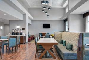 a waiting room with a couch and tables and chairs at Hampton Inn And Suites Macclenny I-10 in Macclenny