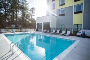 a swimming pool in front of a building at Hilton Garden Inn Southern Pines Pinehurst, Nc in Aberdeen