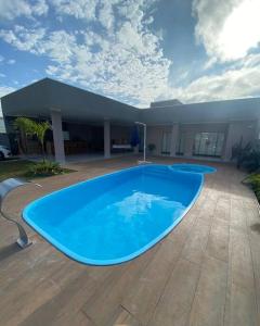 een groot blauw zwembad voor een huis bij Casa Com Piscina em Pousada Oasis do Paranapanema in Santo Inácio