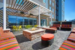 a patio with a fire pit and chairs and tables at Home2 Suites By Hilton Columbus in Columbus