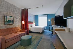 Habitación de hotel con sofá, cama y escritorio. en Home2 Suites By Hilton Columbus en Columbus