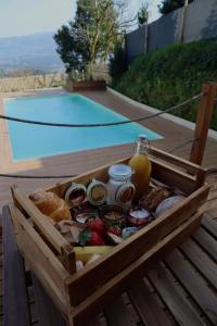 a wooden crate filled with food next to a pool at Casas da Madrinha in Arcos de Valdevez