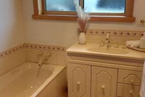 a bathroom with a tub and a sink and a bath tub at Valentine House in Hadspen