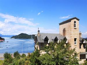 a large brick building next to a body of water at Paper island pension in Tongyeong