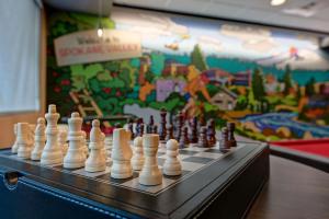 a chess board with chess pieces on a table with a mural at Tru By Hilton Spokane Valley, Wa in Spokane Valley