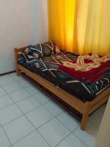 een bed in een kamer met een geel gordijn bij Bidadari Pool in Port Dickson
