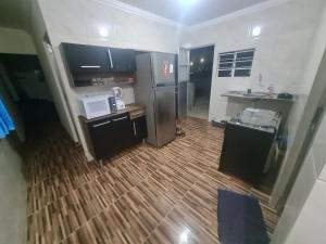 a kitchen with a stainless steel refrigerator and a wooden floor at Casa mobiliada para descanso e para viajantes se hospedarem por temporada in Bayeux