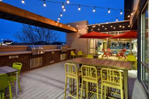 eine Terrasse mit einem Holztisch und Stühlen in der Unterkunft Home2 Suites Wichita Downtown Delano, Ks in Wichita