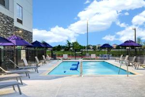 a swimming pool with lounge chairs and umbrellas at Hampton Inn & Suites Houston East Beltway 8, Tx in Houston