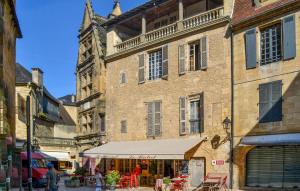 ein altes Gebäude mit einem Zelt davor in der Unterkunft Cozy Home In Montignac With Kitchenette in Montignac