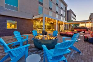 a patio with blue chairs and a fire pit at Home2 Suites Wilmington in Wilmington