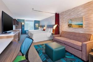 um quarto de hotel com uma cama e um sofá em Home2 Suites Wilmington em Wilmington