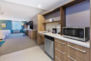 a hotel room with a kitchen and a bedroom at Home2 Suites Wilmington in Wilmington