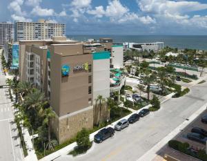 eine Luftansicht auf ein großes Gebäude mit einem Parkplatz in der Unterkunft Home2 Suites By Hilton Pompano Beach Pier, Fl in Pompano Beach