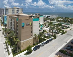帕诺滩Home2 Suites By Hilton Pompano Beach Pier, Fl的享有带停车场的大型建筑的空中景致