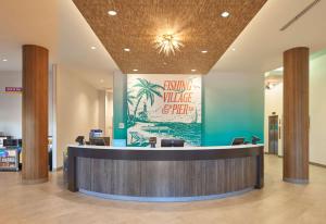 a lobby with a reception desk and a sign at Home2 Suites By Hilton Pompano Beach Pier, Fl in Pompano Beach
