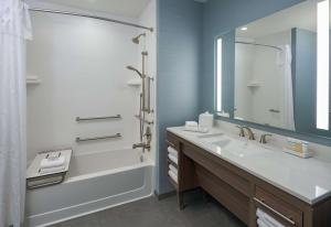 帕诺滩Home2 Suites By Hilton Pompano Beach Pier, Fl的带水槽、浴缸和镜子的浴室