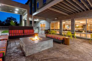 een patio met banken en een vuurplaats bij Home2 Suites By Hilton Grand Blanc Flint, Mi in Grand Blanc