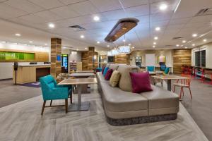 グランド・ブランにあるHome2 Suites By Hilton Grand Blanc Flint, Miのリビングルーム(ソファ、テーブル、椅子付)