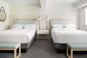 2 camas en una habitación con paredes blancas en Hampton by Hilton Grand Cayman Seven Mile Beach, en George Town
