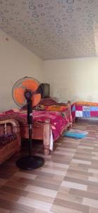 1 dormitorio con 2 camas y ventilador en el suelo en Dreams River view homestay coorg B en Kushālnagar