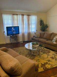 a living room with a couch and a flat screen tv at Home Away From Home in Columbia