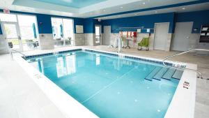 - une grande piscine d'eau bleue dans un bâtiment dans l'établissement Hampton Inn & Suites St Clairsville, Oh, à Saint Clairsville