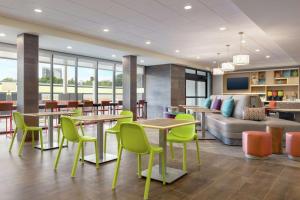Home2 Suites by Hilton New Brunswick, NJ في نيو برونزيك: لوبي به طاولات وكراسي وأريكة