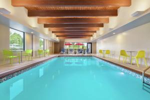 a swimming pool with chairs and tables in a hotel at Home2 Suites by Hilton New Brunswick, NJ in New Brunswick