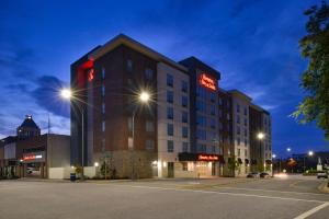 ein Hotelgebäude mit einem Schild am Abend in der Unterkunft Hampton Inn & Suites Greensboro Downtown, Nc in Greensboro