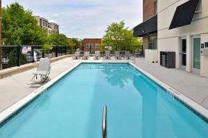 a swimming pool with blue water in a building at Hampton Inn & Suites Greensboro Downtown, Nc in Greensboro