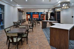 a restaurant with tables and chairs and a bar at Hampton Inn & Suites Greensboro Downtown, Nc in Greensboro