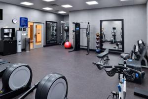 einen Fitnessraum mit mehreren Laufbändern und Kardiogeräten in der Unterkunft Hampton Inn & Suites Greensboro Downtown, Nc in Greensboro