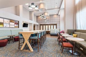 Hampton Inn & Suites Alachua I-75, FL في ألاتشوا: غرفة طعام مع طاولات وكراسي وبار