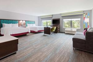 a hotel room with two beds and a couch at Hampton Inn & Suites Alachua I-75, FL in Alachua