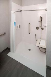 baño blanco con ducha y lavamanos en Hampton Inn & Suites Huntington Downtown, Ny en Huntington