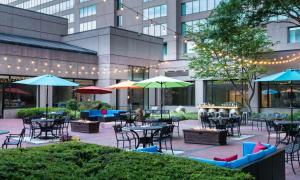 an outdoor patio with tables and chairs and umbrellas at Hilton Fairfax, Va in Fairfax