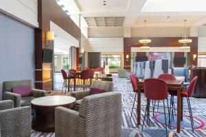 Hilton Fairfax, Va في فيرفاكس: لوبي الفندق مع كراسي وطاولات وبار