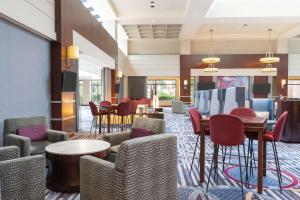 a hotel lobby with chairs and tables and a bar at Hilton Fairfax, Va in Fairfax