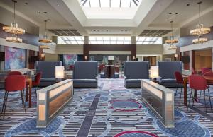 a lobby of a hotel with chairs and tables at Hilton Fairfax, Va in Fairfax