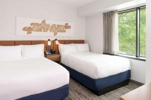 a hotel room with two beds and a window at Hilton Fairfax, Va in Fairfax