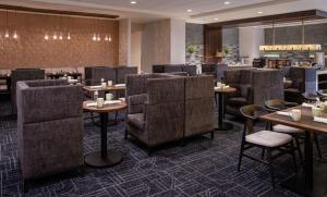 a restaurant with tables and chairs in a room at Hilton Fairfax, Va in Fairfax