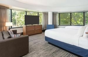 a hotel room with a bed and a flat screen tv at Hilton Fairfax, Va in Fairfax